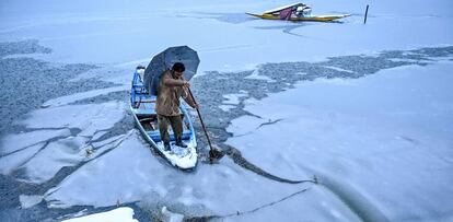Un hombre navega con su bote en erl Lago Dal, durante la nevada del 13 enero, en Srinagar (India).