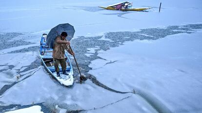 Un hombre navega con su bote en erl Lago Dal, durante la nevada del 13 enero, en Srinagar (India).