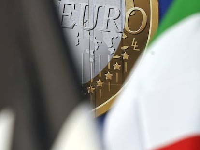 La insignia del euro tras varias banderas.