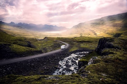 Una furgoneta ‘camper’ circula por una sinuosa carretera de Islandia.