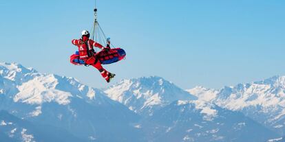 Un helicóptero de la compañía Air Zermatt traslada al esquiador Meike Pfister durante el entrenamiento del descenso femenino de la Copa del mundo de esquí alpino, este jueves en Crans-Montana (Suiza).