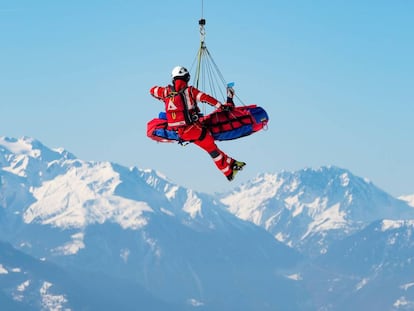 Un helicóptero de la compañía Air Zermatt traslada al esquiador Meike Pfister durante el entrenamiento del descenso femenino de la Copa del mundo de esquí alpino, este jueves en Crans-Montana (Suiza).