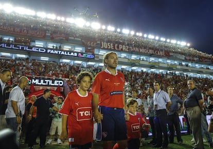 Gaby Milito salta a la cancha junto a sus hijos Santiago (i) y Lucas (d).