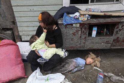 Marcela, 21 anos, amamenta sua filha Amber, de um ano, do lado de fora de sua casa danificada pelo terremoto em Talcahuano.