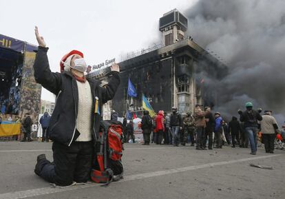 Una manifestante reza tras las barricadas.