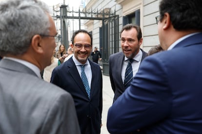  Los diputados socialistas Antonio Hernando (en el centro, a la izquierda) y Óscar Puente (en el centro, a la derecha) conversan a las puertas de la Cámara baja.