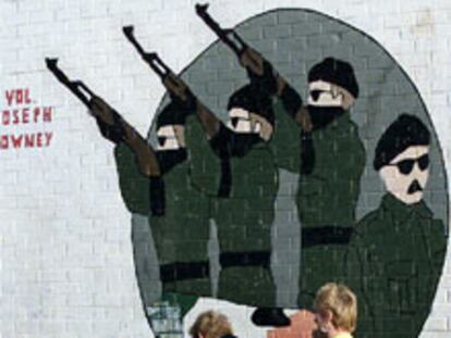 Dos mujeres pasan ante una pintada de apoyo al IRA en Belfast.