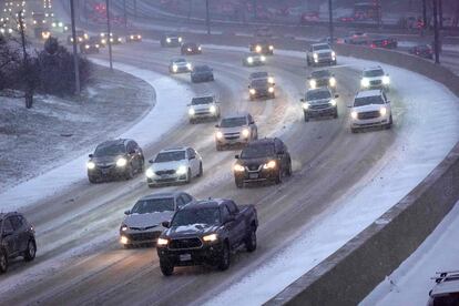 Autos transitan por una autopista Kennedy cubierta de nieve durante una hora pico vespertina en Chicago, Illinois, el 22 de diciembre.