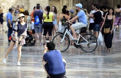 Una pareja de turitas se fotografian en la plaza de la Virgen.