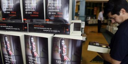 Un cliente contempla un ejemplar al lado de una pila de libros de la obra de Stieg Larsson &#039;La reina en el palacio de las corrientes de aire. Millenium 3&#039;.