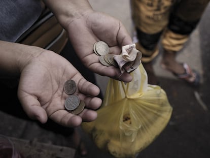 Una mujer muestra monedas y billetes en Colombia.