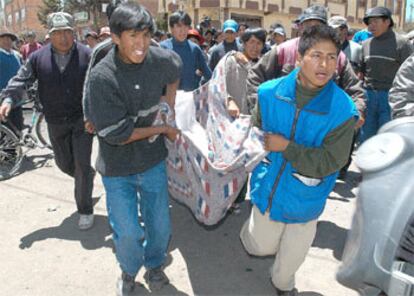 Vecinos de El Alto trasladan a un joven que recibió un balazo.