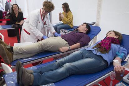 Dues persones donen sang a l'hospital de campanya instal·lat a la plaça de Catalunya.