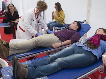 Dues persones donen sang a l'hospital de campanya instal·lat a la plaça de Catalunya.