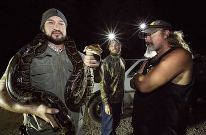 Joe Medina (izquierda) posa con un reptil recién capturado.