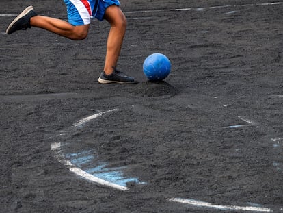 Un chico juega al fútbol sobre la ceniza del volcán de La Palma.