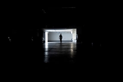 Un hombre camina en un estacionamiento durante un corte de energa, este martes en Santiago.