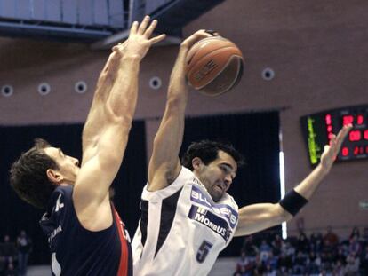 El pivot montenegrino del Caja Laboral, Vladimir Golubovic (i) lucha por un rebote con el base Andrés Rodríguez, durante el partido de baloncesto disputado hoy en el Multiusos de Sar de Santiago de Compostela