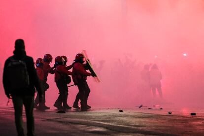 Varios agentes de la Ertzaintza se protegen ante el lanzamiento de objetos en la entrada del estadio San Mamés.