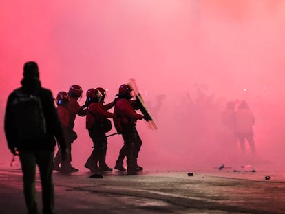 Varios agentes de la Ertzaintza se protegen ante el lanzamiento de objetos en la entrada del estadio San Mamés.