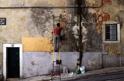 Un hombre arregla la fachada de su casa en el barrio de Alfama en Lisboa (Portugal). El Ejecutivo portugués reconoció que las tasas de crecimiento registradas en el primer semestre de 2014 son peores de lo que sería deseable, aunque insistió en que, aun así, son superiores a la media europea.