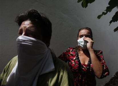 Xiomara Castro, esposa de Manuel Zelaya, y una simpatizante (en primer plano) se cubren la cara en la Embajada brasileña en Tegucigalpa.