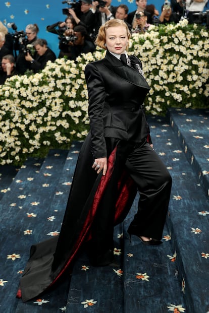 Sarah Snook ('Succession'), combinó negro y rojo con este traje satinado de larga levita con forro carmesí.