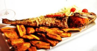 Plato de pescado con banana frita y ensalada.