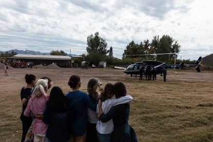Miembros de la familia LeBarón observan al helicóptero que traslada a uno de los cuerpos previo a los funerales.