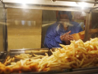 Un empleado de un restaurante de comida rápida de La Paz (Bolivia) coge patatas fritas.