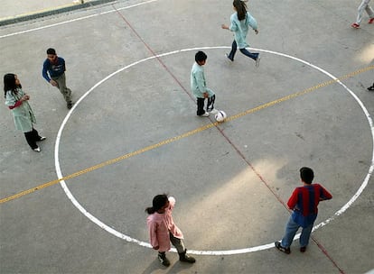 Niños jugando a fútbol en el patio del colegio Pompeu Fabra de Reus.