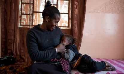 Mbayam Diop, de 30 años y esposa de emigrante, acaricia a su hija Mamita en el salón de su vivienda en Gandiol, en el distrito senegalés de Saint Louis.