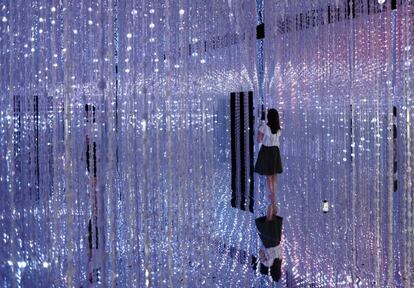 Una visitante visita la instalación digital titulada 'Wander through the Crystal Universe' ('Vagar por el universo de cristal') presentada por el collectivo artístico teamLab en Tokio (Japón).