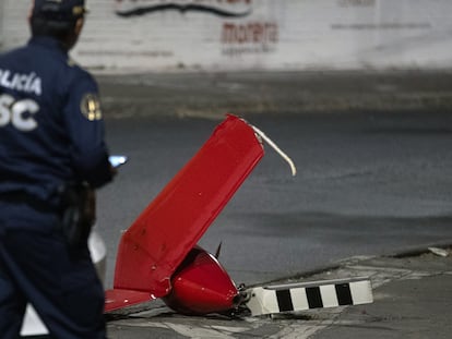 Un policía inspecciona una parte de la cola del helicóptero que se desplomó la tarde del 14 de abril, en Ciudad de México.