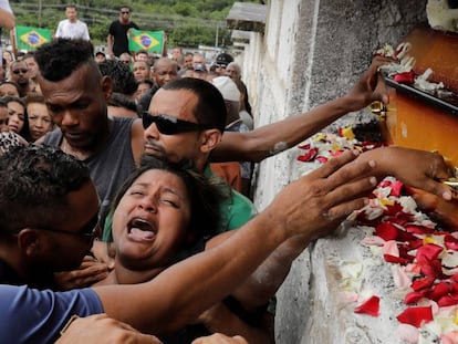Luciana Nogueira, esposa de Evaldo Rosa dos Santos, no enterro do marido. Amigos do músico protestaram com bandeiras do Brasil manchadas de vermelho