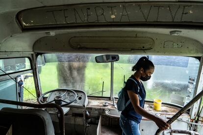 Araceli Soriano, alumna de la Escuela Normal Rural Vanguardia de Tamazulapam del Progreso, baja de uno de los camiones abandonados de colegio.