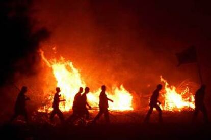 Varios palestinos pasan frente a la sinagoga incendiada de Netzarim.