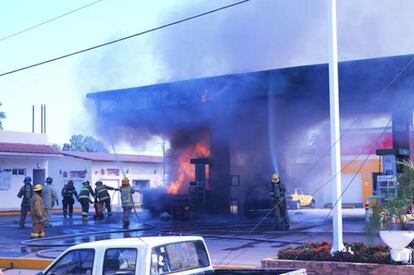 Bombeiros tentam apagar o incêndio de um posto de gasolina de Puerto Vallarta, onde também foram queimadas quatro agências bancárias.