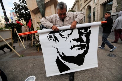 Un hombre muestra una imagen del difunto presidente de Chile, Salvador Allende, durante una manifestación conmemorativa del 45 aniversario del golpe militar de Chile en 1973, en Santiago de Chile.