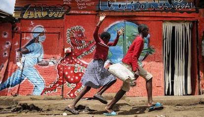 Unos niños corren por delante de un mural que previene de los peligros de la covid-19 en Nairobi, Kenia, el 3 de junio de 2020.   