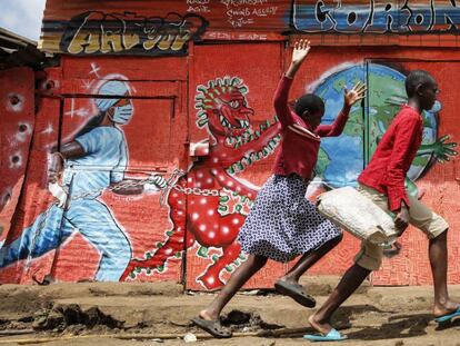 Unos niños corren por delante de un mural que previene de los peligros de la covid-19 en Nairobi, Kenia, el 3 de junio de 2020.   