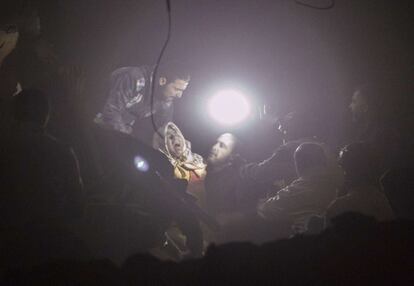 Una mujer es rescatada entre los escombros de un edificio destrozado durante un bombardeo por las fuerzas del ejército sirio en Kalasa cerca de la ciudad de Alepo (Siria).