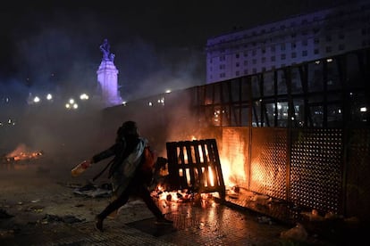 Una mujer arroja una botella a los agentes de la polica antidisturbios a las afueras del Congreso Nacional en Buenos Aires (Argentina).