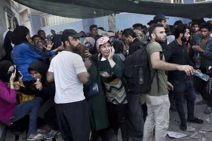 Los inmigrantes tratan de protegerse de las piedras en el puerto de Mitilene, en la isla griega de Lesbos.