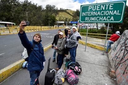 Migrantes venezolanos se fotografían frente a la señal del puente internacional de Rumichaca, frontera entre Ecuador y Colombia. 