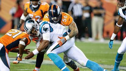 Cam Newton recibe un placaje de los Broncos, el jueves.