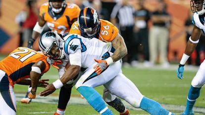 Cam Newton recibe un placaje de los Broncos, el jueves. 