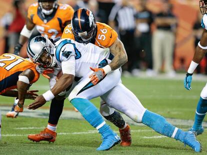 Cam Newton recibe un placaje de los Broncos, el jueves. 