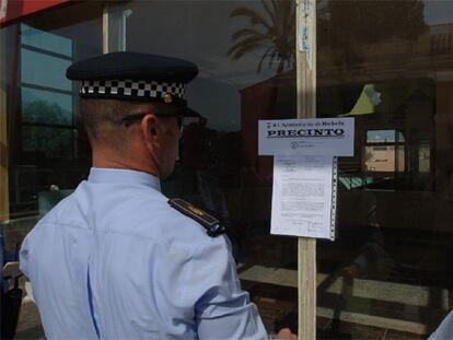 Un agente de la Policía Local observa el precinto ordenado por la gestora de Marbella.