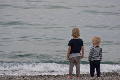 Dos hermanos están juntos en la playa.